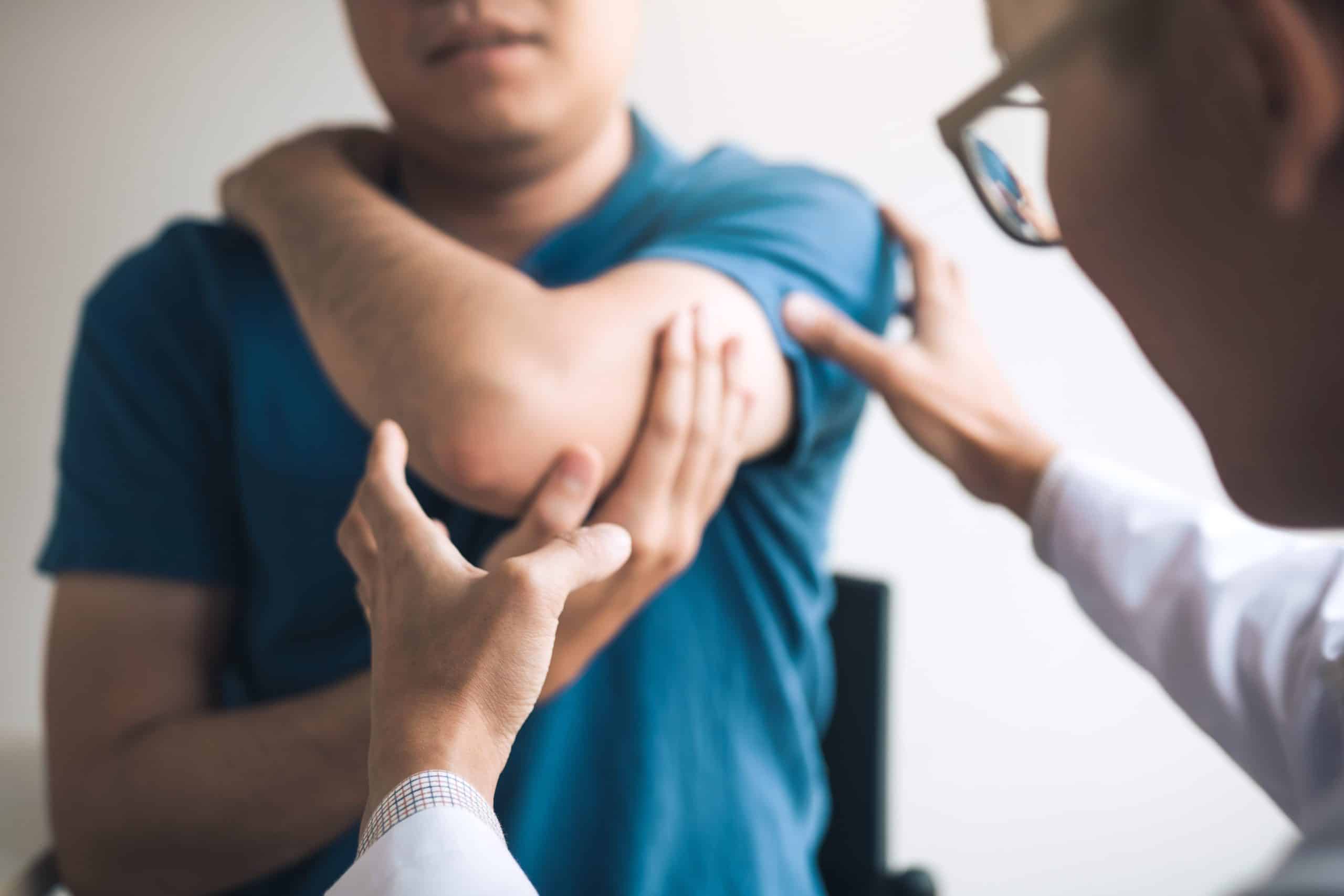Doctor checking patients elbows at the clinic office room. iSpine serves chronic pain conditions